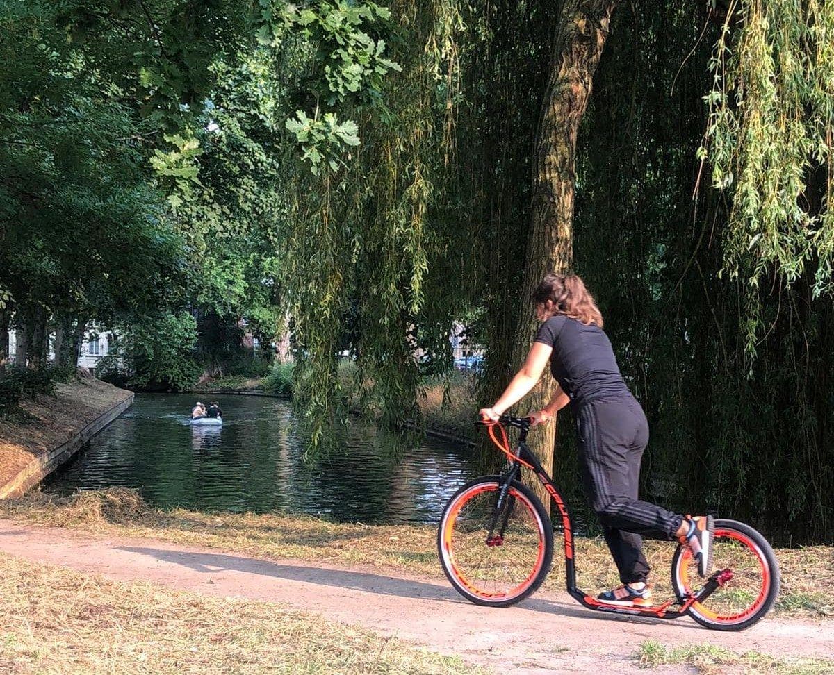 Steppen met een gehuurde kickbike langs het water in een Utrechts park
