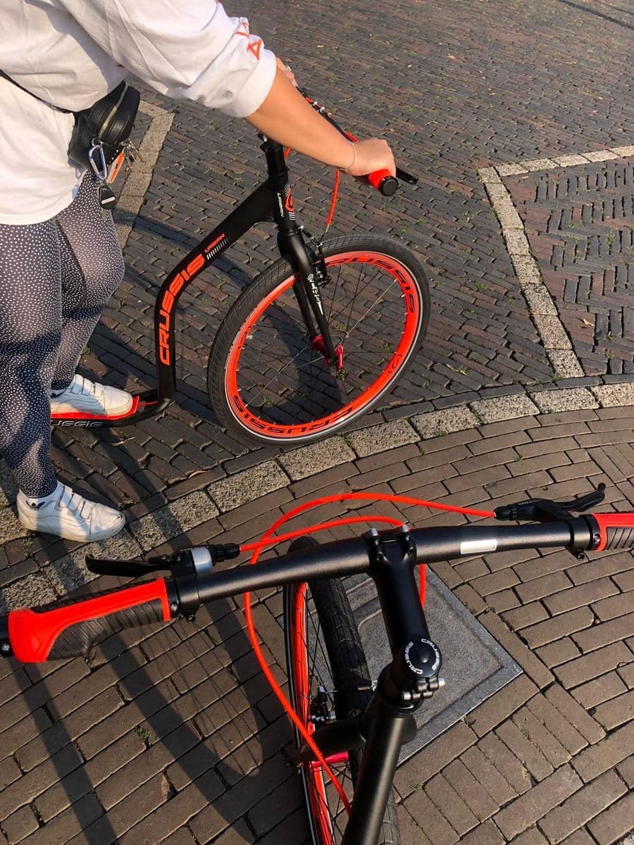 Nahaufnahme eines Kickbikes: ein Tretroller für Erwachsene mit großem Vorderrad, niedrigem Trittbrett und Fahrradlenker