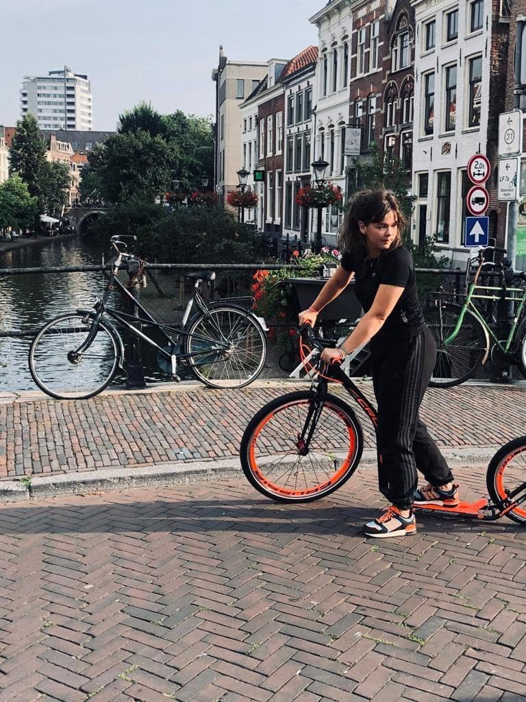 Jemand mit einem gemieteten Kickbike an der Oudegracht in Utrecht